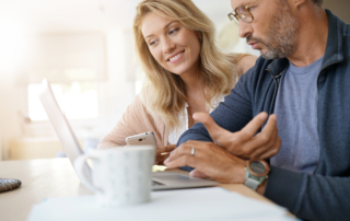 a man and woman looking at a laptop